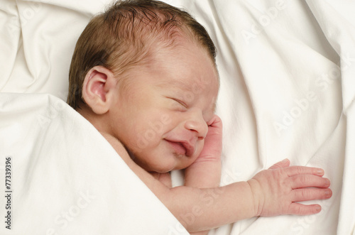 Newborn baby boy smiling in his sleep.Ten days baby laughing.