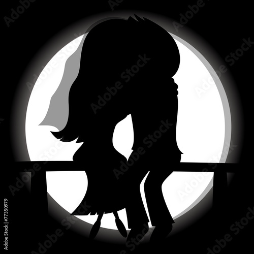 Silhouette of a newlywed couple sit on a bench with a full moon.
