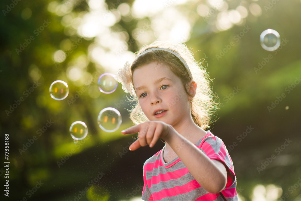 Little girl is playing with soap bubbles Little girl is playing with soap bubbles