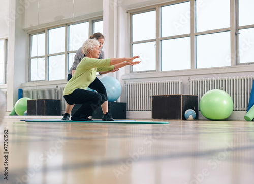 Senior woman doing exercise with her personal trainer