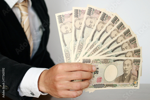 お札の束を持つビジネスマン　Businessman holding bills photo