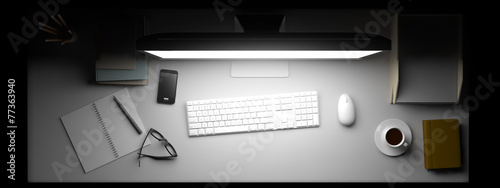 Top view of workspace with computer and other elements on table.