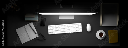 Top view of workspace with computer and other elements on table.