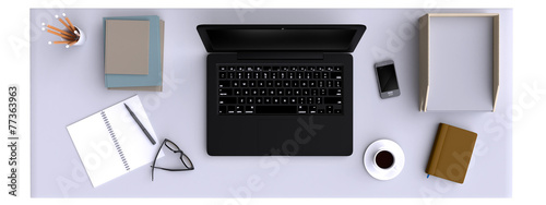 Top view of workspace with laptop and other elements on table.