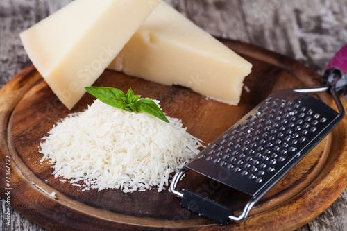 grated parmesan cheese and metal grater on wooden board