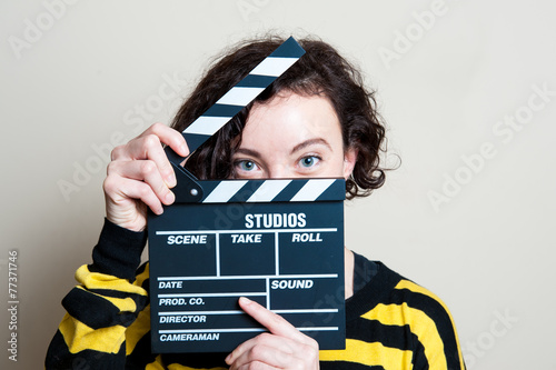 Obraz na plátne Smiling girl with movie clapper on white background