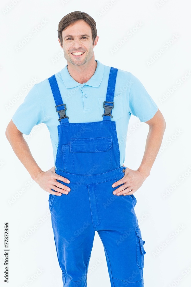 Happy carpenter in overalls with hands on hip Happy carpenter in overalls with hands on hip