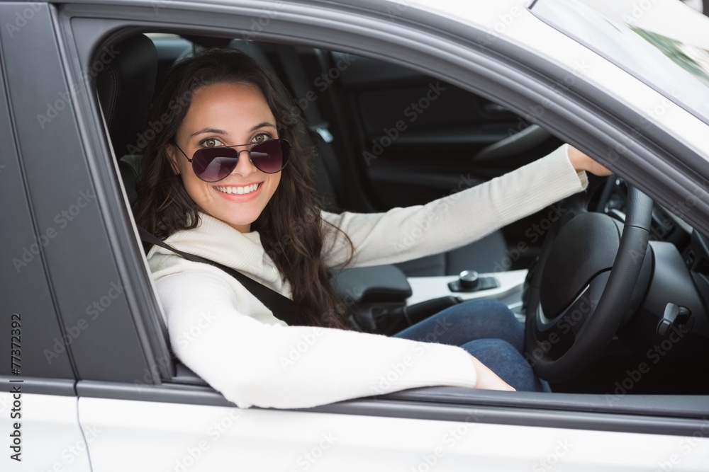 Pretty woman wearing sunglasses and driving