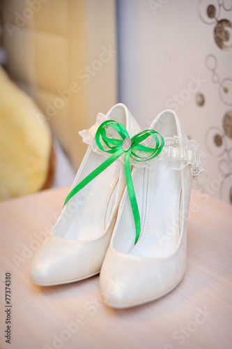 Luxury wedding shoes. Elegant bridal shoes and a white garter