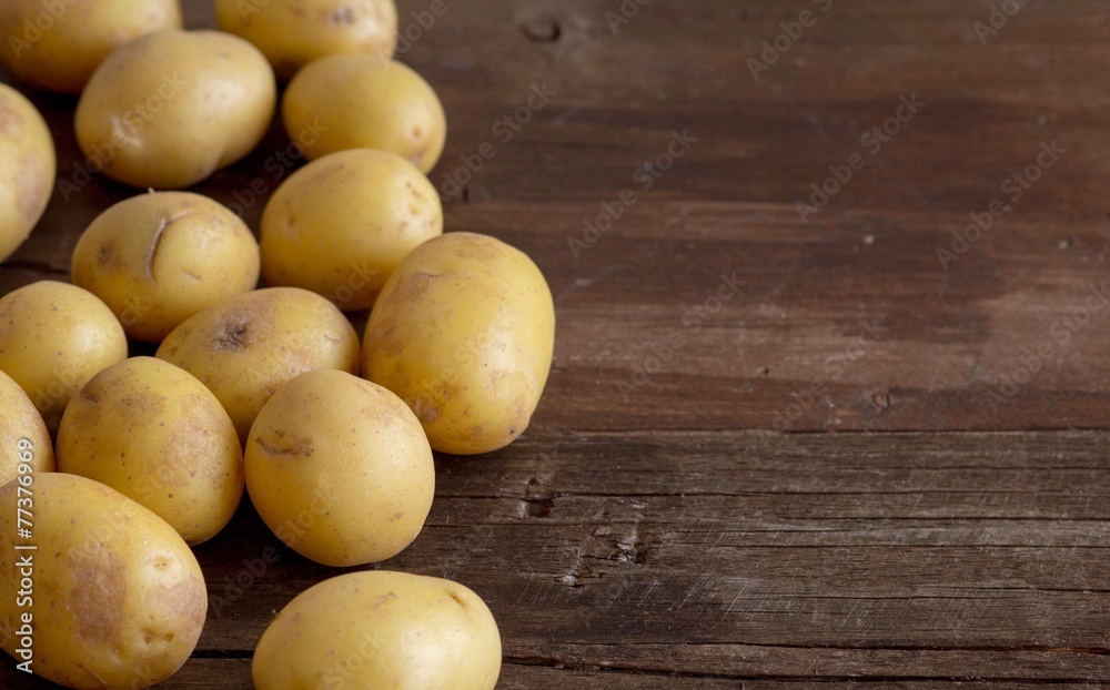 Young small potatos on wooden background