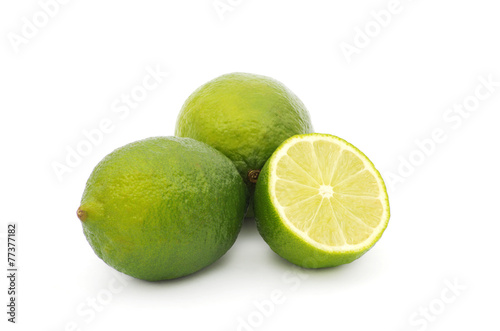 Limes with slices and leaves isolated on white background
