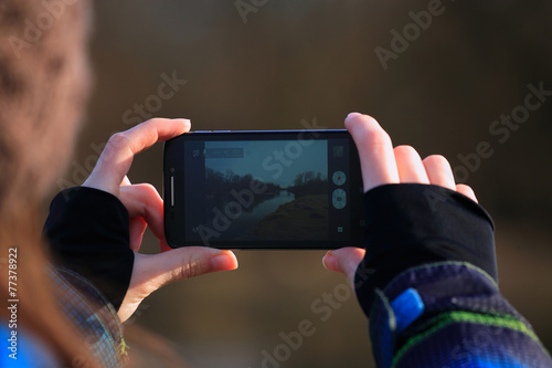 Young girl use her mobile for making photo