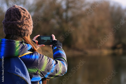 Young girl use her mobile for making photo