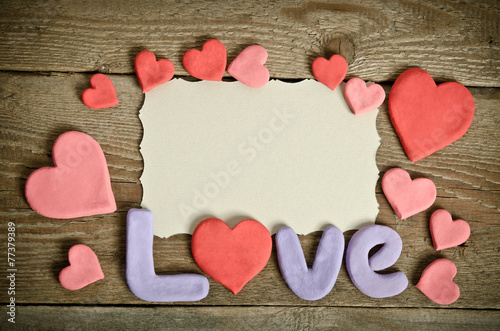 Word Love composition on the wooden board surface and many heart