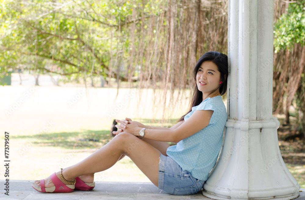 Asian woman portriat sitting  smiling in the park