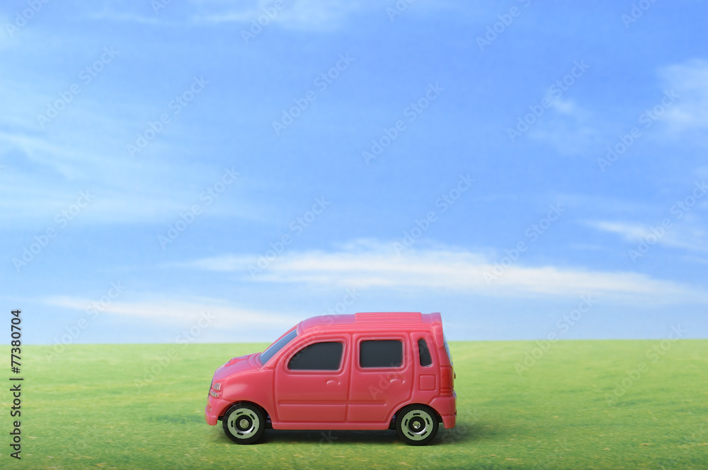青空と草原と赤いワゴン車