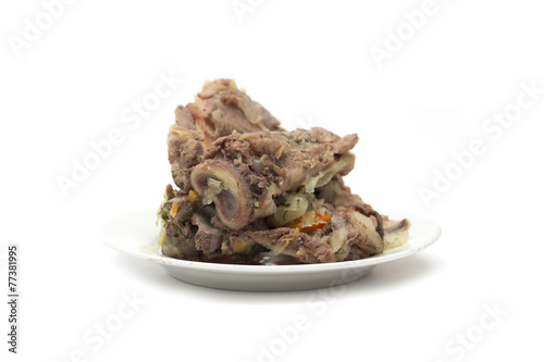 Bone with meat on a plate. Photo.
