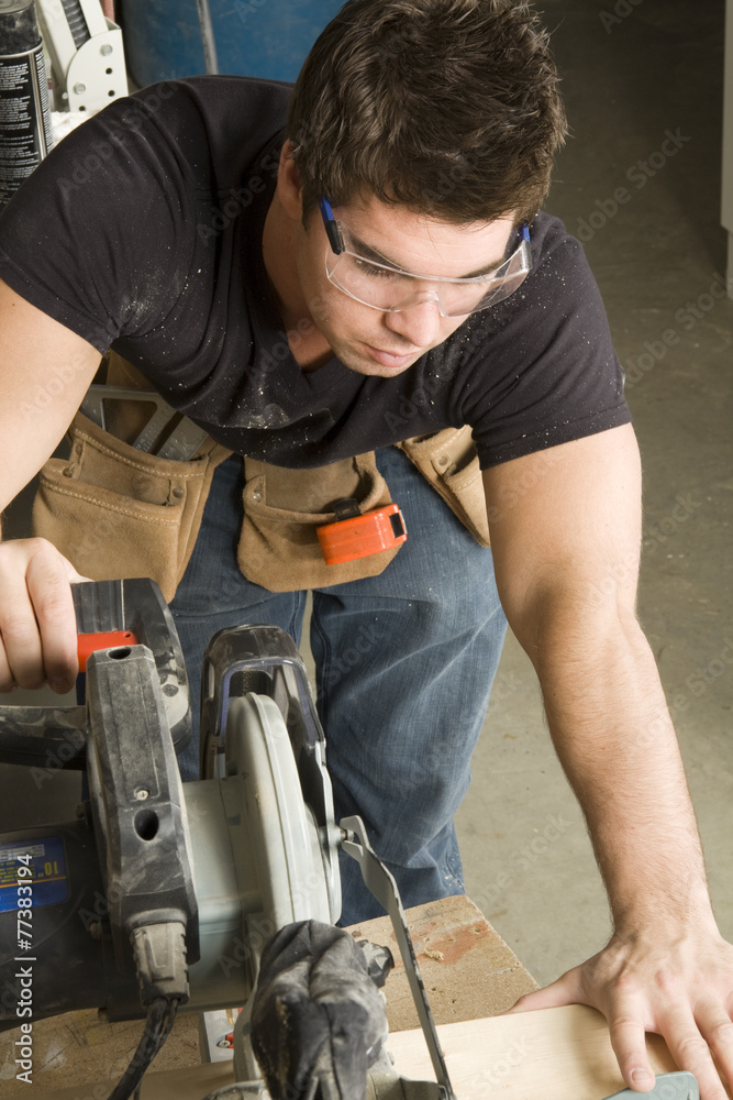 Carpenter at work on job using power tool Carpenter at work on job using power tool