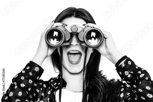 Surprised girl looking through binoculars black and white
