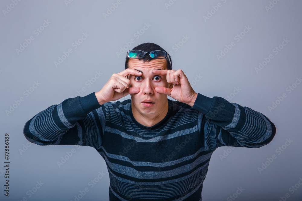 European-looking male of about thirty brunet stretches eyes with European-looking male of about thirty brunet stretches eyes with