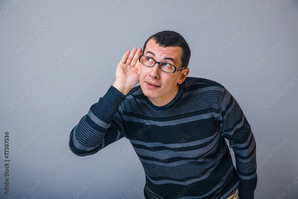 male of European appearance brunet put his hand to ear, eave