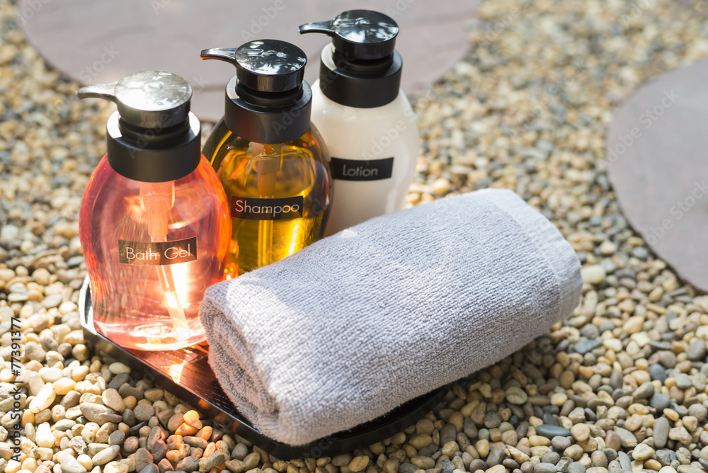Amenity set : Shampoo, bath gel, soap and lotion on pebbles floor Amenity set : Shampoo, bath gel, soap and lotion on pebbles floor