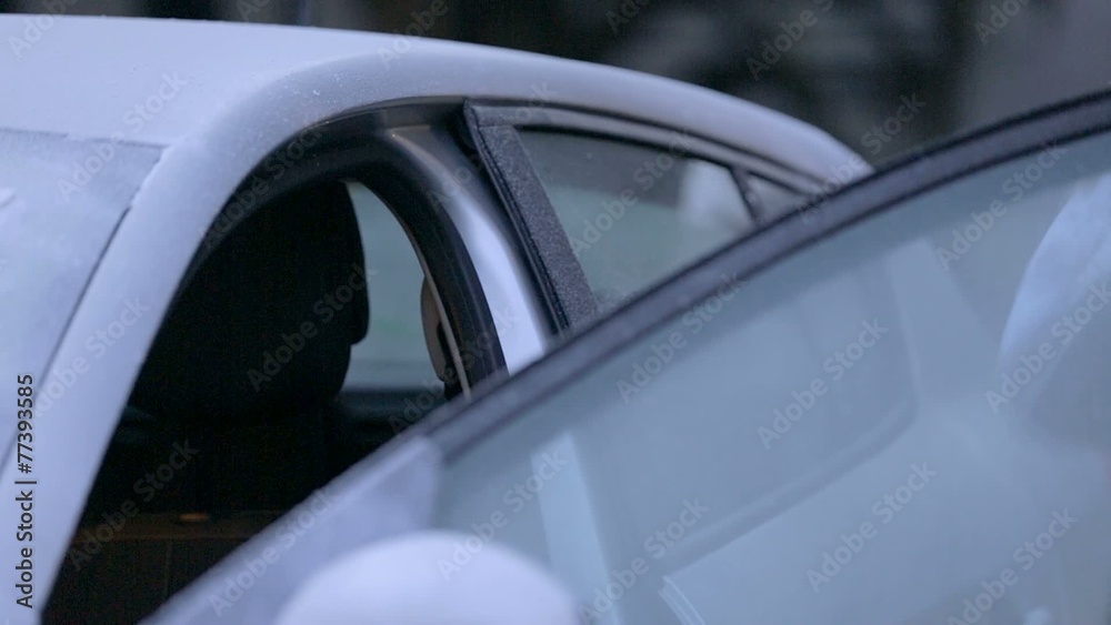 A guy in national costume places accordion inside of his icy car A guy in national costume places accordion inside of his icy car