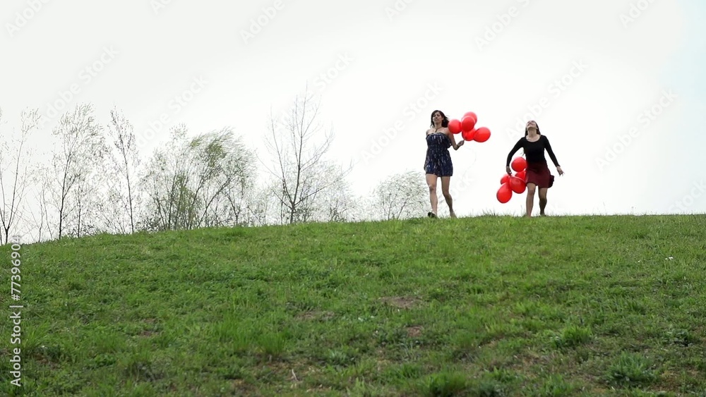 Two Attractive Woman Running Down The Hill With Red Balloons Two Attractive Woman Running Down The Hill With Red Balloons