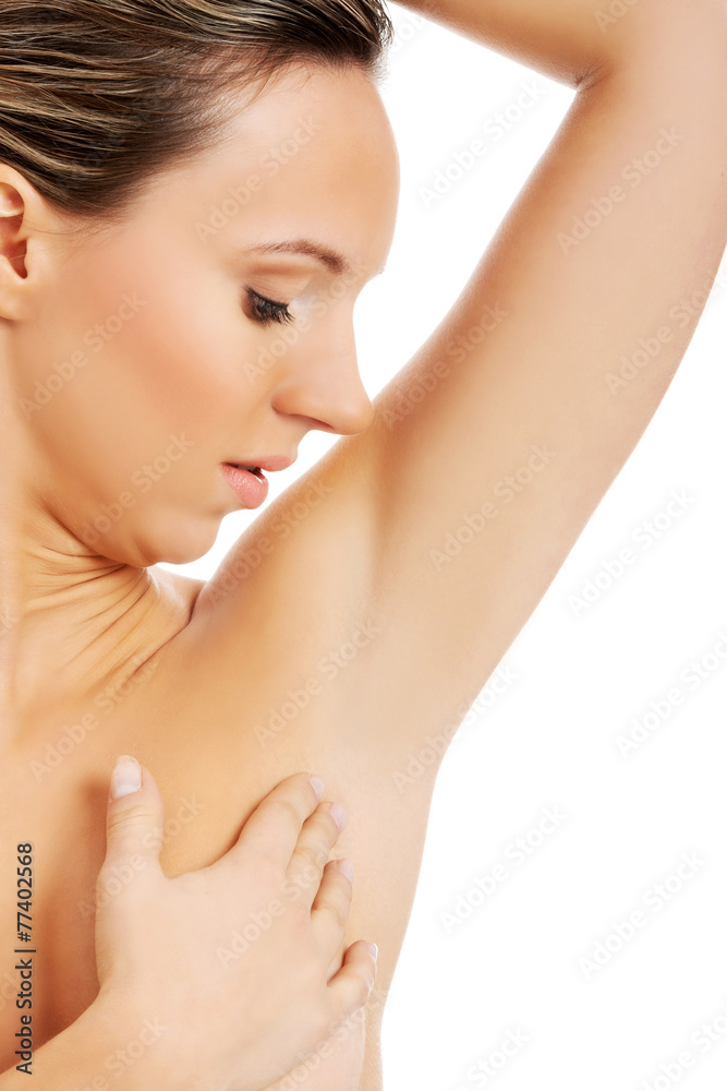 Beautiful and topless woman is touching her armpit.