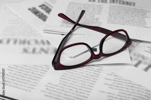 Glasses and newspapers  close-up