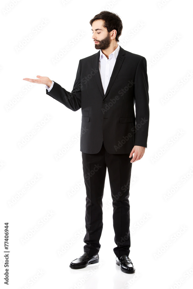 Young businessman showing empty copyspace on hand. Young businessman showing empty copyspace on hand.