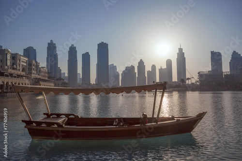 Dubai lagoon with boat against sunset in UAE