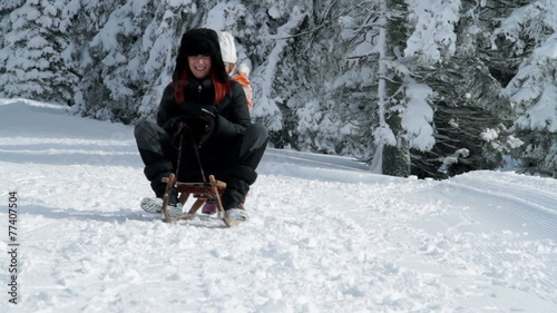 a family with children while sledding and enjoying in the idyllic winter time soroundings photo