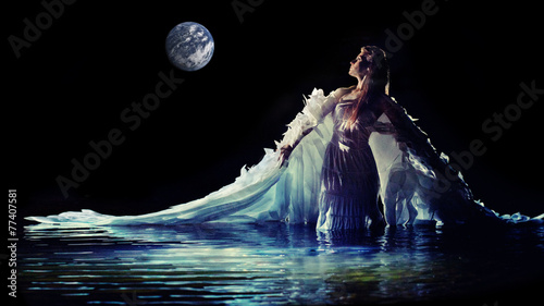 Tablou canvas Beautiful white angel is standing in the water.