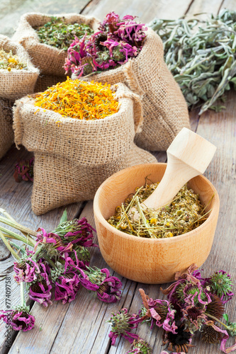 Healing herbs in wooden mortar and in hessian bags, herbal medic