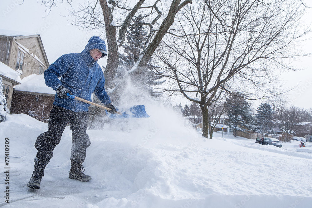 Man Removing Snow from His Driveway with a Shovel