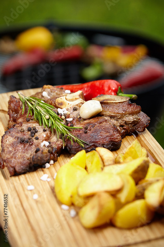 T-bone steak on the barbecue grill with vegetable spears in the