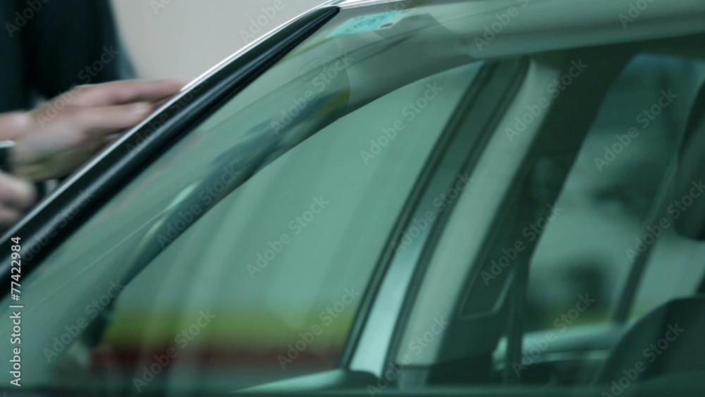 Man knocking to check if the windshield is fixed Man knocking to check if the windshield is fixed