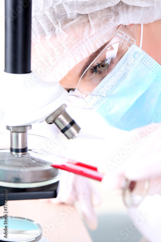 Female scientist using microscope in laboratory