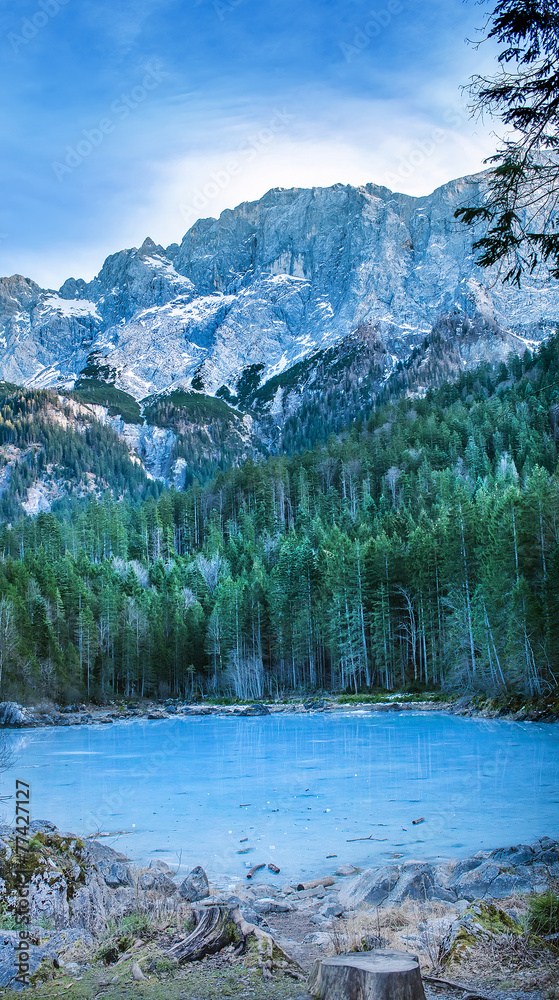 Frozen forest lake in Bavarian Alps near Eibsee lake