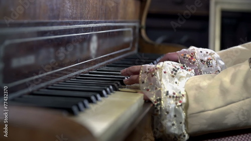 Detail shot of mistress hands pressing piano keys photo