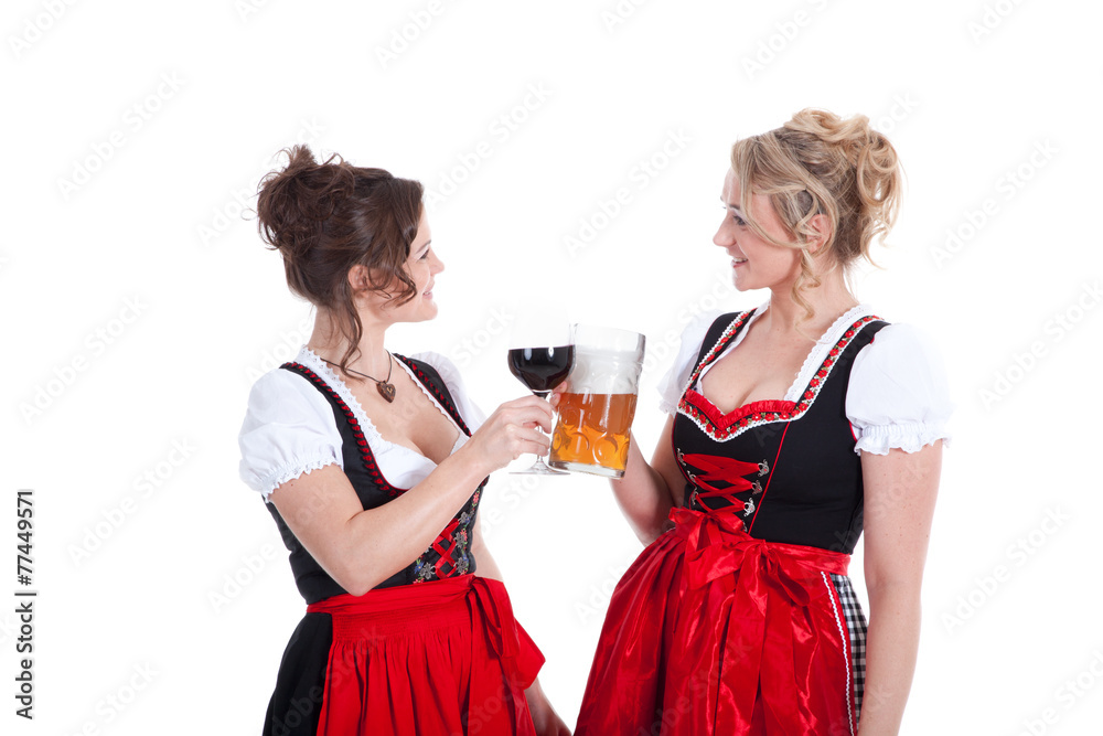 Frauen im Dirndl mit Rotwein und Bier stoßen an Porträt Frauen im Dirndl mit Rotwein und Bier stoßen an Porträt