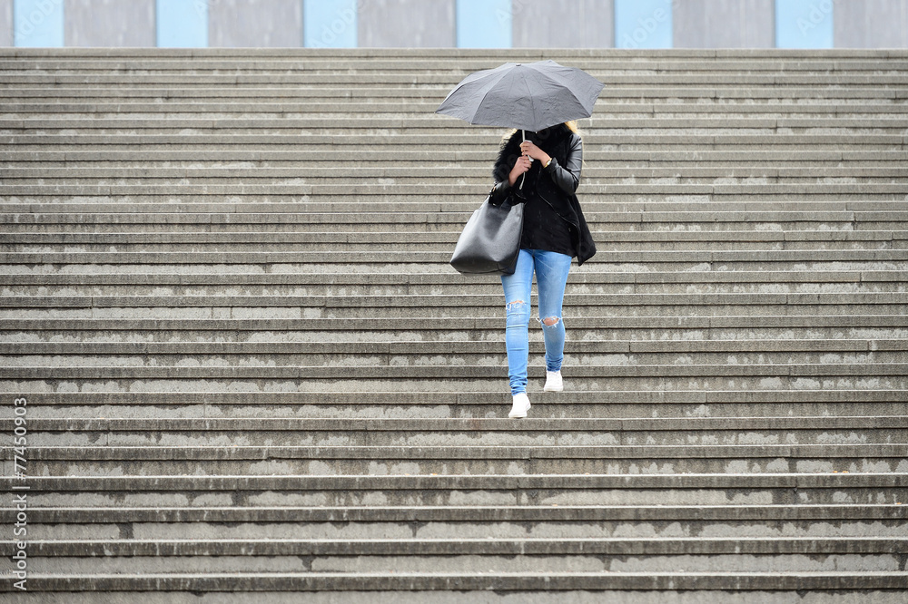 Young adult woman walks down the stairs in the rain Young adult woman walks down the stairs in the rain