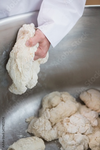 Close up of baker preparing dough in industrial mixer