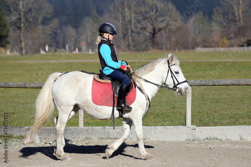 junges Mädchen reitet auf Pferd
