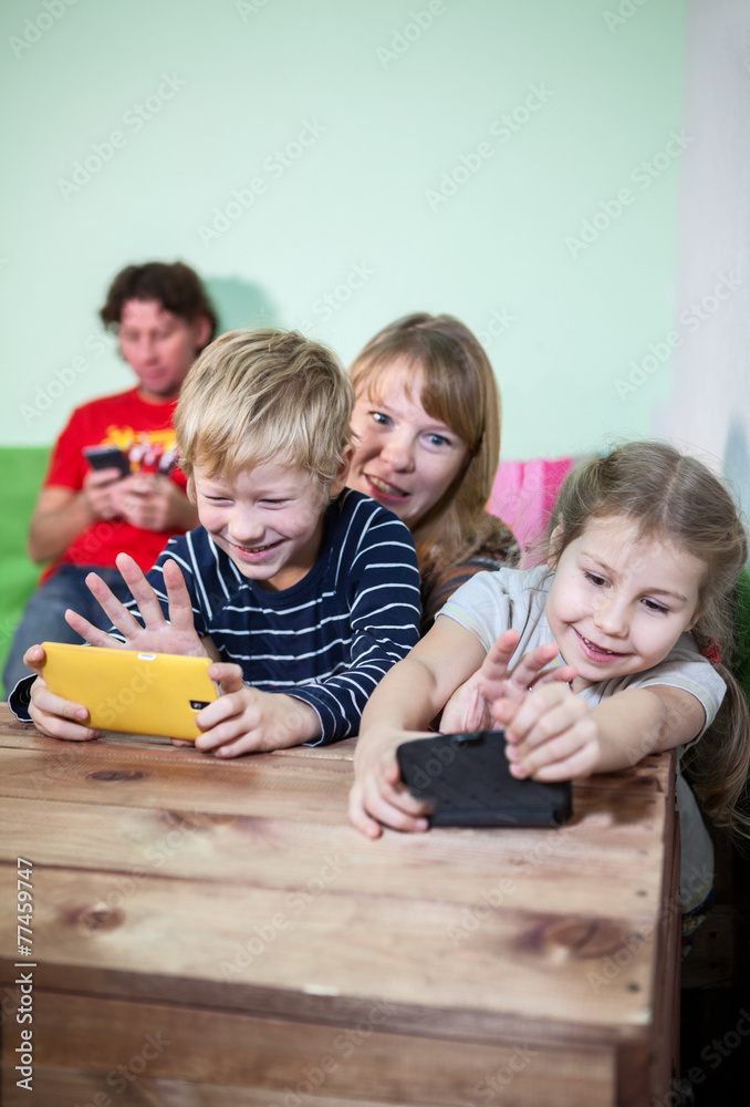 Mom taking away tablets pc from son and daughter, living room Mom taking away tablets pc from son and daughter, living room