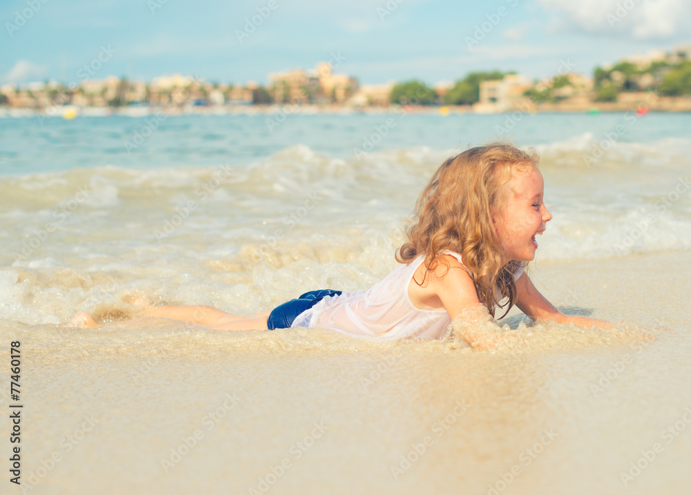 Fototapeta premium Little girl having fun on beach vacation. Place for text.