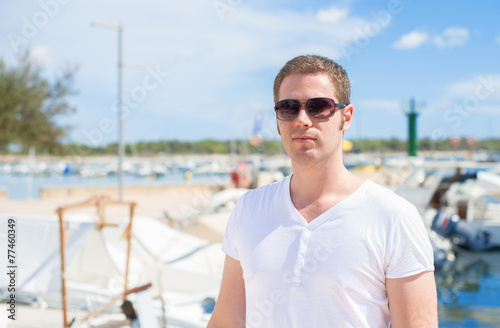 Man portrait against of the pier with yachts.