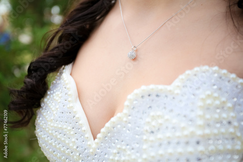 The pendant on the neck of the bride