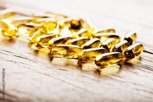 Fish oil omega 3 gel capsules  on wooden background